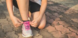 femme faisant ses lacets de chaussures de sport