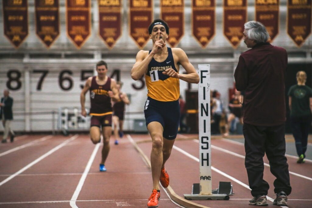 Coureur franchissant la ligne d’arrivée lors d’une course en salle