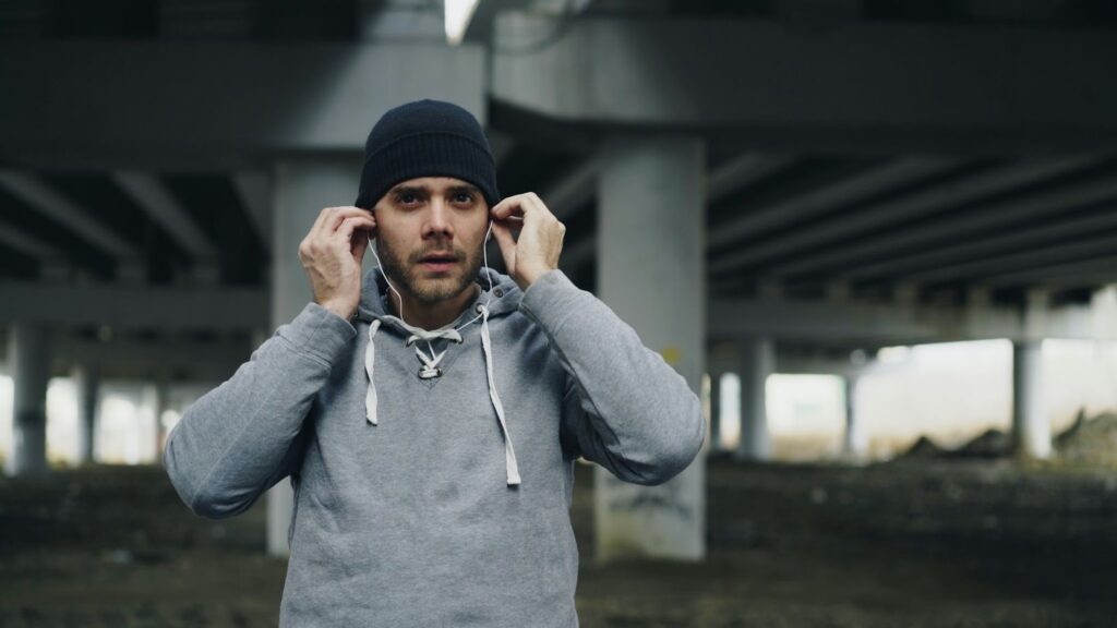 Un athlète mettant ses écouteurs sur le terrain, illustrant l'usage de la musique dans le rituel